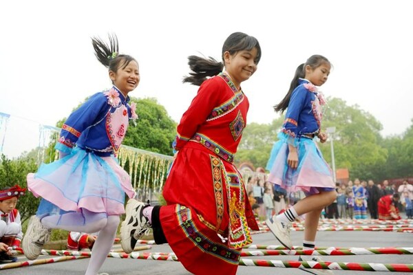 Photo taken on April 13, 2024, shows that three girls of Yanglin Village are dancing on the long bamboo poles. (Photo by Chen Qihai)