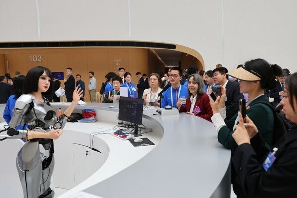 Visitors interact with a humanoid robot at the opening of the 2024 Zhongguancun Forum in Beijing on Thursday. [Photo by WANG ZHUANGFEI  CHINA DAILY]