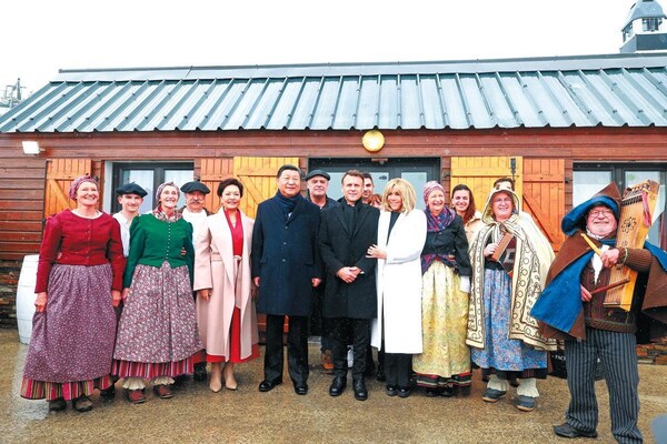 President Xi Jinping and his wife, Peng Liyuan, pose for a photo on Tuesday with French President Emmanuel Macron and his wife, Brigitte Macron, as well as local residents, after a welcoming performance at Col du Tourmalet in southwestern France. China Daily