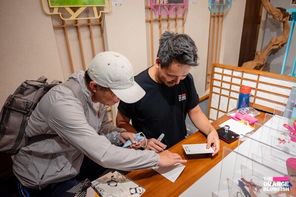 创意总监Siu Tang为到场参观的人员奉上武康明信片的专属签名