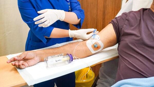 Pantai Hospital Kuala Lumpur OPAT patient being outfitted with a Baxter elastomeric pump bottle that infuses antibiotics over a 24-hour period