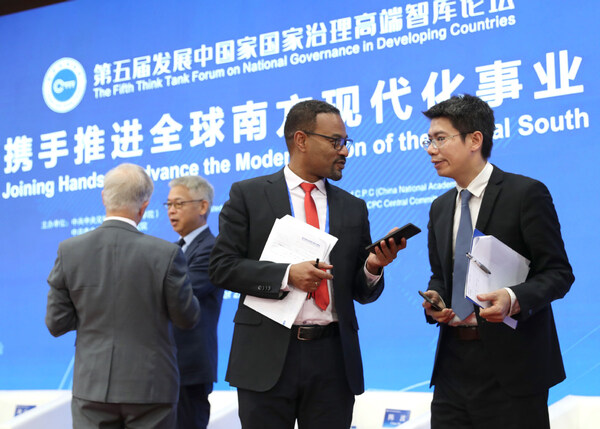 Endalkachew Sime (second right), former state minister of planning and development of Ethiopia, talks with Zhou Taidong, vice-president of the Center for International Knowledge on Development at the Fifth Think Tank Forum on National Governance in Developing Countries in Beijing on Friday. (PRNewsfoto/China Daily)