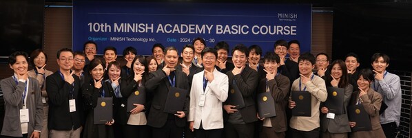 Jeong-ho Kang, CEO of MINISH Technology (center, in white), Masaki Hayashizaki, Chairman of Hanshōkai Medical Corporation (to Kang's left), and other graduates of the MINISH Academy pose for a commemorative photo.