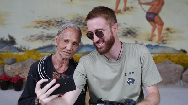 Italian vlogger Fabio Nodari takes a selfie with a Li elder in Hainan's Binglanggu (Betel Nut Valley) Li and Miao Cultural Tourism Area.