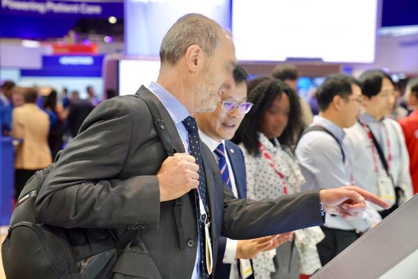 [Photo 2] An attendee listens to a presentation on STAgora™ at Seegene’s booth at ADLM 2025 in Chicago.