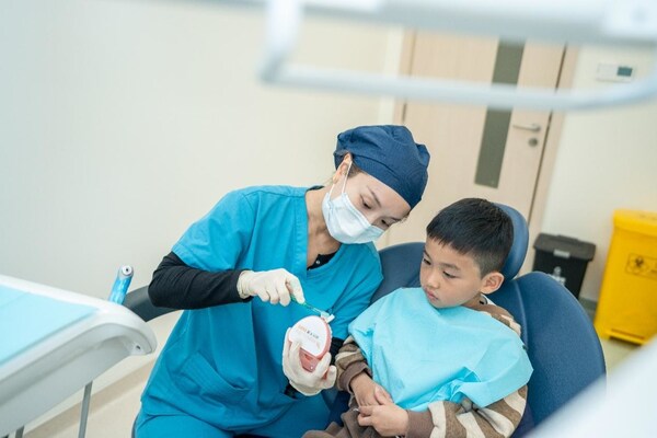 口腔科医生正在为小朋友进行细致的牙齿检查 口腔科医生正在为小朋友进行细致的牙齿检查